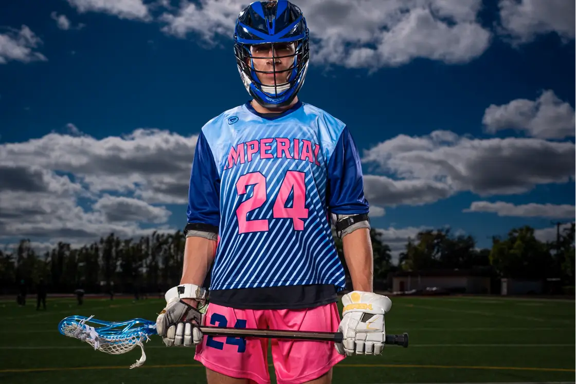 reversible-lacrosse-pinnies Male lacrosse player stands in full gear, wearing an Imperial Point reversible jersey.
