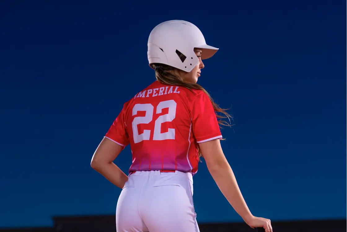 slowpitch-softball-jerseys Back of a female softball player wearing a white helmet and Imperial Point jersey.
